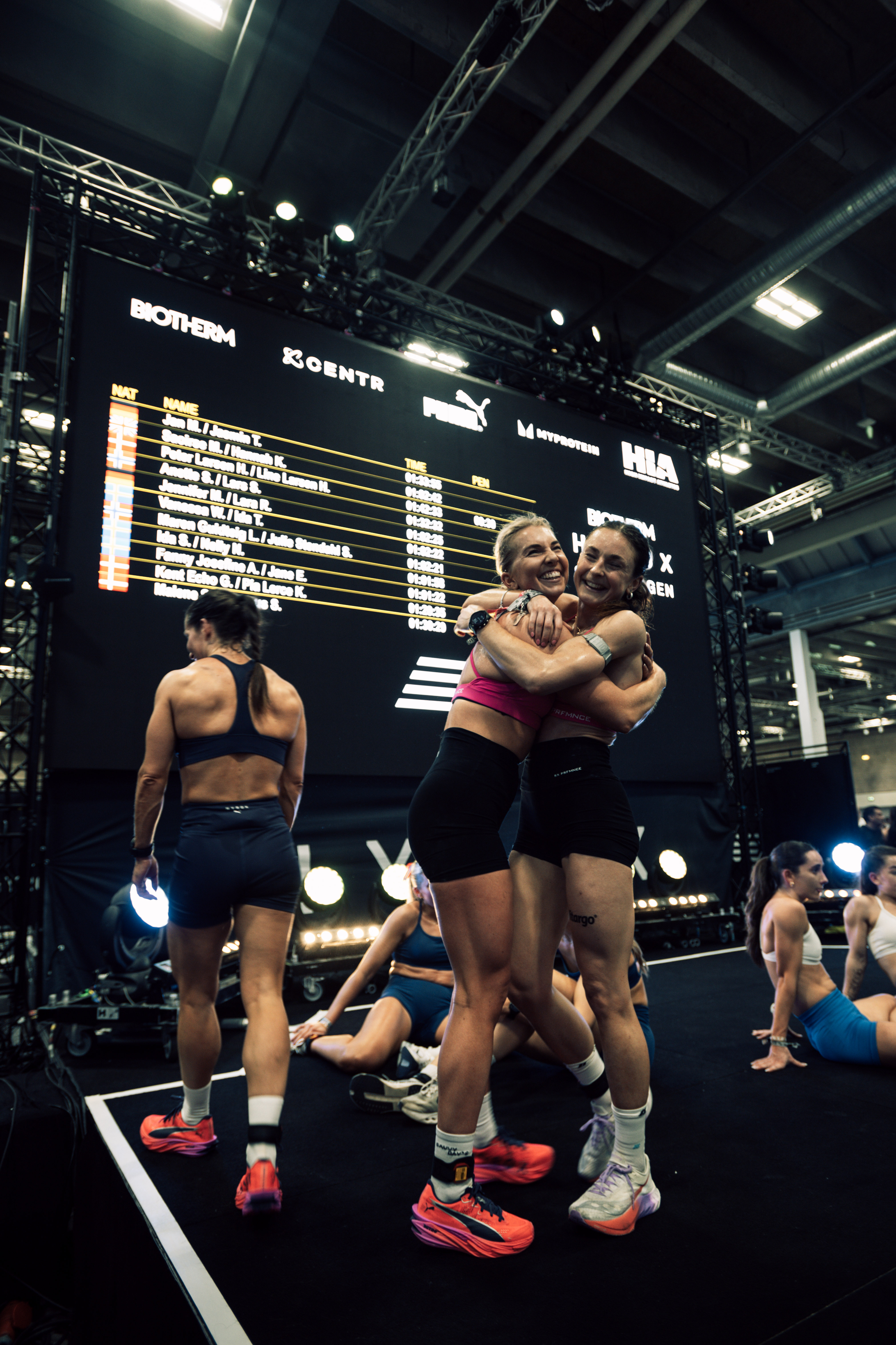 Two HYROX athletes celebrating at the finish line